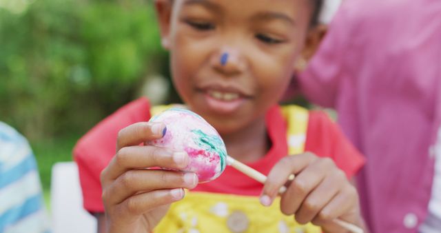 Image of happy african american girl painting easter eggs in garden - Download Free Stock Photos Pikwizard.com