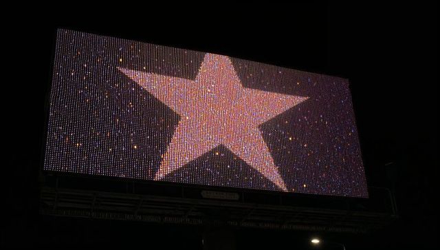 Illuminated led billboard displaying giant star at night on urban roadside