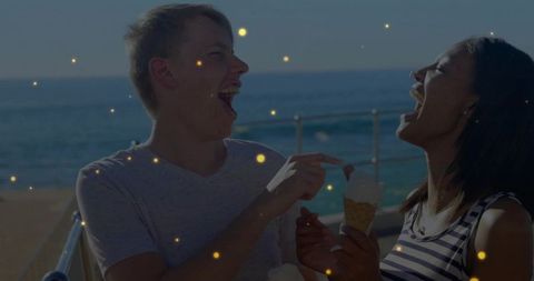 Joyful Couple Sharing Ice Cream by Sparkling Oceanic Horizon