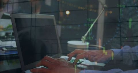 Businessman Analyzing Financial Data on Laptop in Modern Workspace