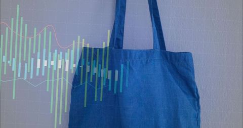 Blue canvas tote bag hanging on pale textured wall with colorful financial chart overlay