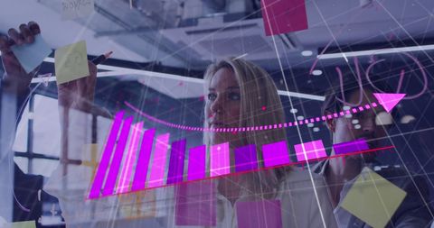 Innovative Businesswoman Analyzing Financial Data on Transparent Board