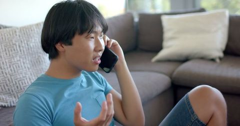 Young Asian Man Speaking On Phone In Casual Setting