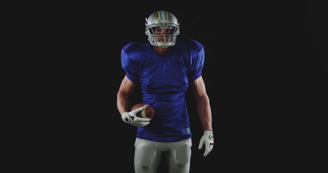 Determined American Football Player Holding Ball in Dark Background - Download Free Stock Images Pikwizard.com