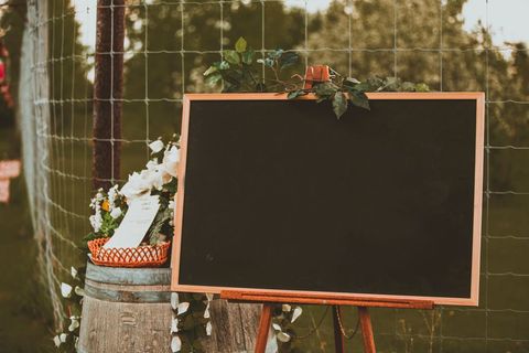 Outdoor blackboard with floral decor at rustic event venue for templates