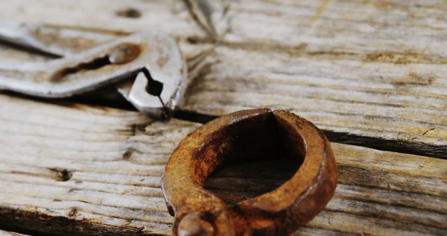 Close-Up of Rusty Handcuff on Weathered Wooden Surface - Download Free Stock Images Pikwizard.com