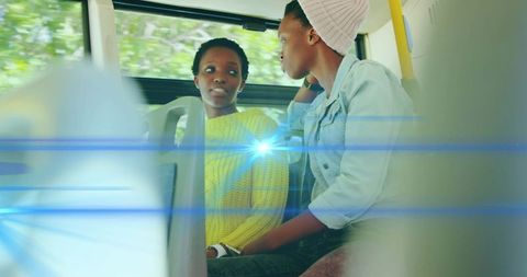 Two Women Engaged in Conversation on Public Bus