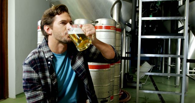 Man enjoying beer in industrial brewery - Download Free Stock Images Pikwizard.com