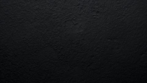 Deep black textured wall background featuring subtle cracks and rough plaster