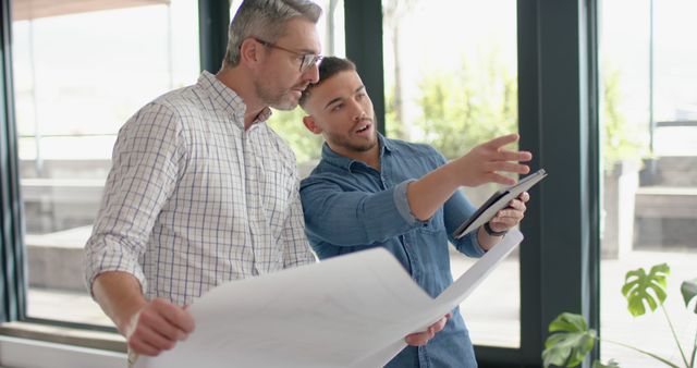 Engineers Discussing Architectural Blueprint in Modern Office - Download Free Stock Images Pikwizard.com