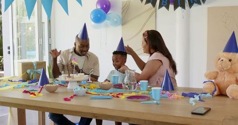 Diverse family joyfully celebrating birthday with cake
