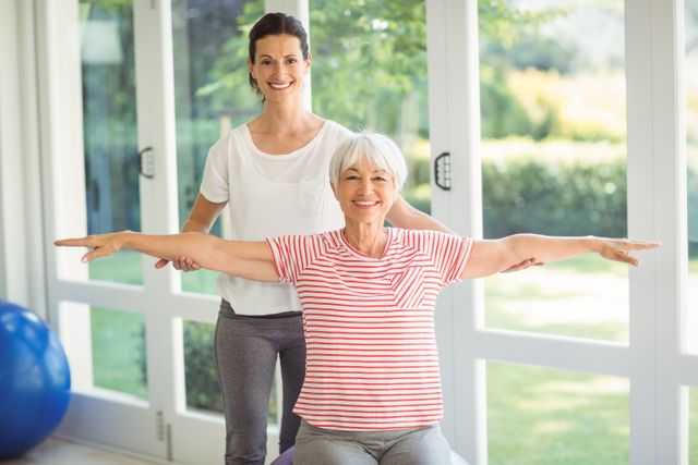 Female Coach Assisting Senior Woman with Exercise at Home - Download Free Stock Photos Pikwizard.com