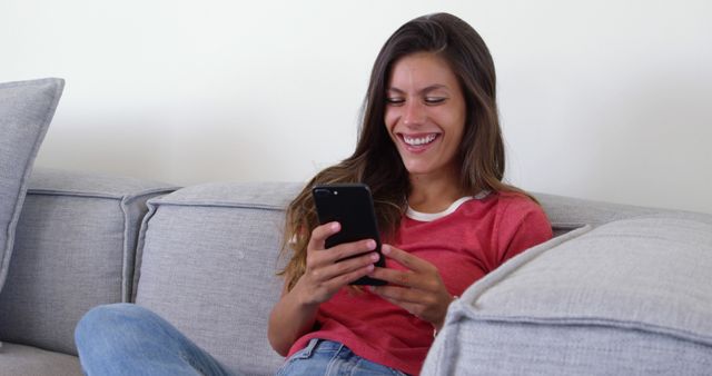 Woman Smiling While Using Smartphone on Couch - Download Free Stock Images Pikwizard.com