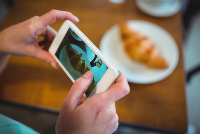Woman Photographing Croissant with Smartphone in Cafe - Download Free Stock Photos Pikwizard.com