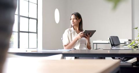 Businesswoman with Tablet Planning Future Projects at Office Desk