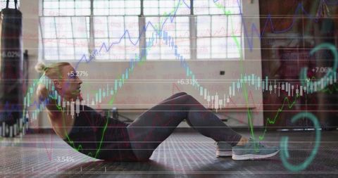 Woman training core doing crunches in sunlit industrial gym with market charts overlay