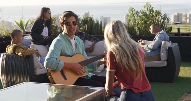 Group of Friends Relaxing on Rooftop Playing Guitar - Download Free Stock Images Pikwizard.com