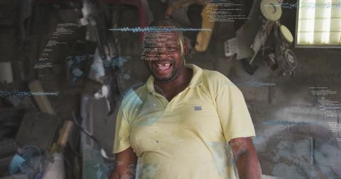 Smiling mechanic working in rustic workshop with digital data overlay for diagnostics