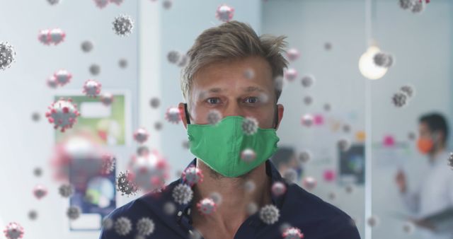 Man Wearing Green Facemask Amid Floating Covid-19 Particles at Office - Download Free Stock Images Pikwizard.com