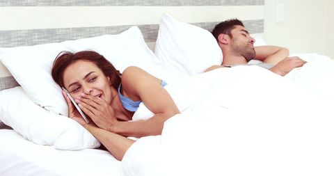Woman on Phone While Man Sleeps in Bed, Intimate Couple Bedroom Scene - Download Free Stock Images Pikwizard.com
