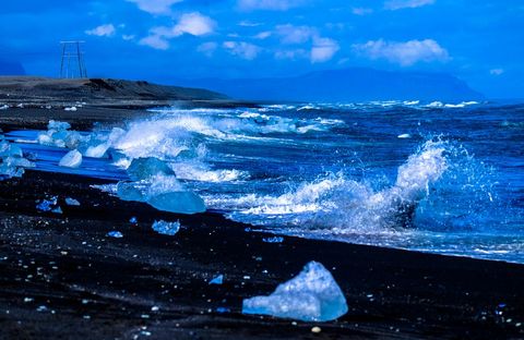 Dramatic waves crashing on icy black sand beach