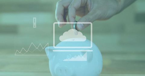 Hand dropping coin into white piggy bank with cloud laptop charts representing savings
