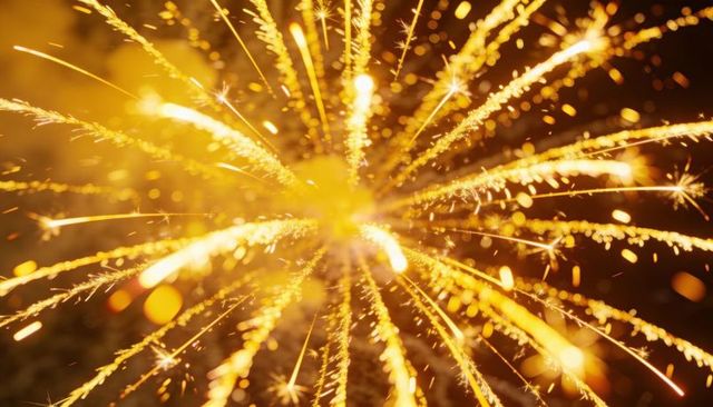 Bursting golden sparkler sending radiant spark trails with bokeh glow macro