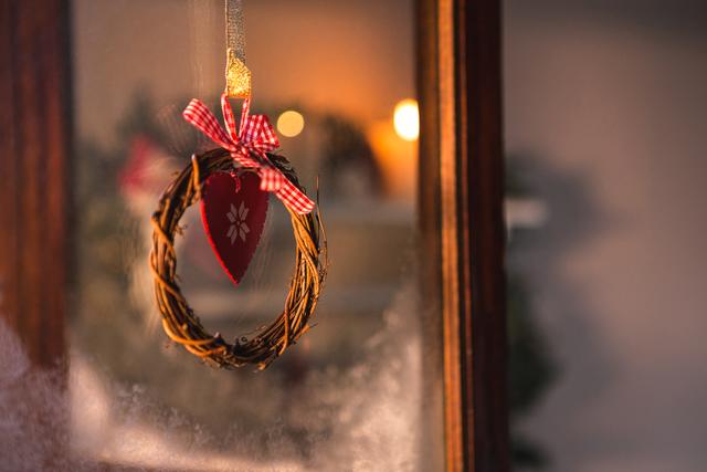 Close-up of christmas grapevine wreath with ribbon hanging on window