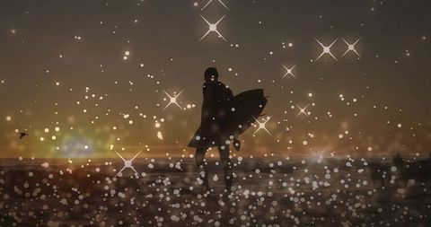 Surfer silhouette walking on wet sand at sunset with star bokeh and calm ocean horizon