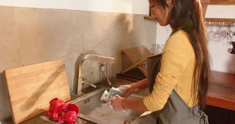 Woman Washing Glass in Minimalist Kitchen With Juicer
