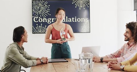 Team celebrating employee achievement with congratulations display