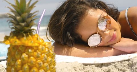 Woman Enjoying Beach Relaxation with Pineapple Drink