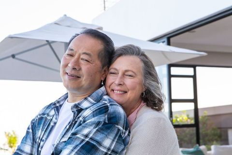 Senior Couple Embracing on Patio Enjoying Sunny Day