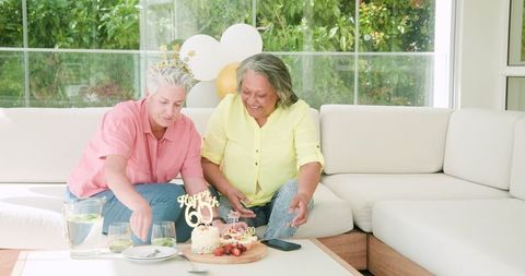 Senior Lesbian Couple Celebrating Birthday with Cake and Joy