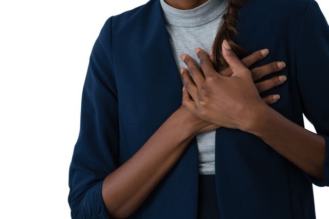 This image shows a woman holding her chest, indicating chest pain or discomfort. It can be used in medical articles, healthcare websites, or educational materials about heart health, stress, anxiety, and emergency situations. The close-up and isolated background make it suitable for focused discussions on health issues.