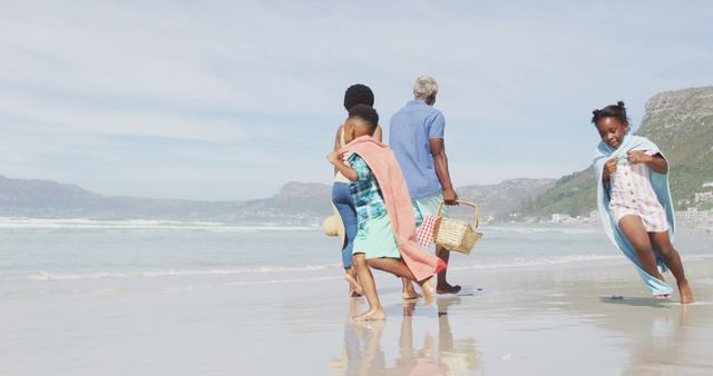 Rear View of Happy Family Walking on Beach with Picnic Still in Tow, Enjoying Vacation - Download Free Stock Images Pikwizard.com