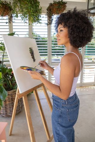 Creative Artist Painting in Sunny Room with Botanical View