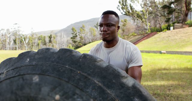 Man flipping large tire during outdoor fitness training in park - Download Free Stock Images Pikwizard.com