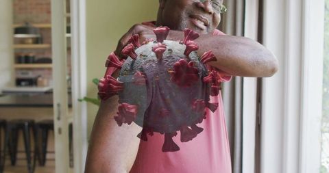 Senior man stretching shoulder at home with 3d coronavirus overlay showing health risk