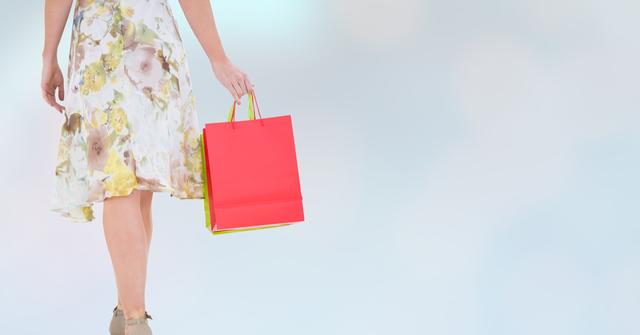Woman in floral dress holding shopping bags against a pastel background. Perfect for use in advertising, retail promotions, fashion blogs, and consumer-oriented content. Conveys themes of shopping, elegance, and modern lifestyle.