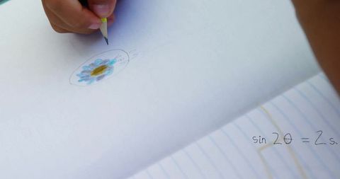Child drawing blue flower and scribbling equation in notepad