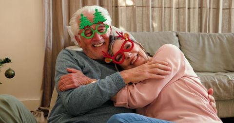 Senior Couple Embracing with Christmas Glasses at Home Festive Scene