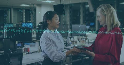 Confident Businesswomen Shaking Hands in Modern Office