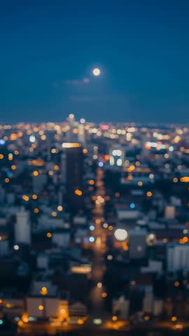 Capturing full moon over blurred bokeh city lights nightscape, vertical cinematic loop