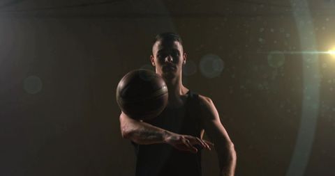 Athletic basketball player mastering ball spin in dimly lit gym