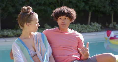 Young Couple Relaxing by the Poolside on Sunny Day