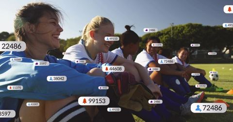 Female soccer players sitting on sideline smiling with social media follower and like badges