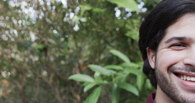 Biracial man smiling face close up with copy space in garden. Masculinity, outdoors, nature and free time concept, unaltered.