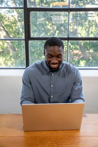 Happy Professional Using Laptop in Bright Office Space