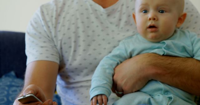 Father Holding Baby while Watching TV at Home - Download Free Stock Images Pikwizard.com